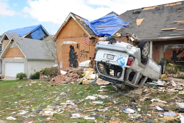 Overturned vehicle and damaged home in St. Louis after tornado.